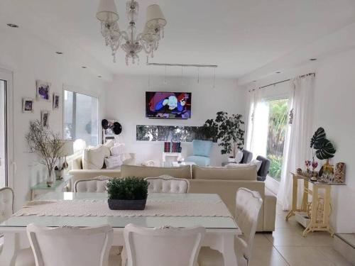 een witte eetkamer met een tafel en stoelen bij HARAS SANTA MARIA in Belén de Escobar