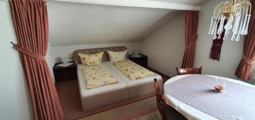 a small bedroom with a bed and a table at Haus Bethania Ferienwohnung grande plus in Bad Kissingen