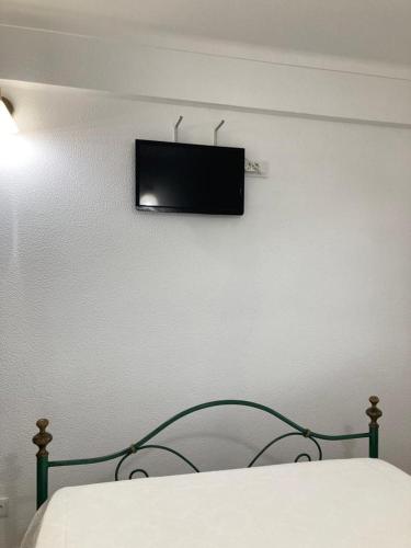 a bedroom with a bed with a television on the wall at Casa da Nazaré in Portinho da Arrábida