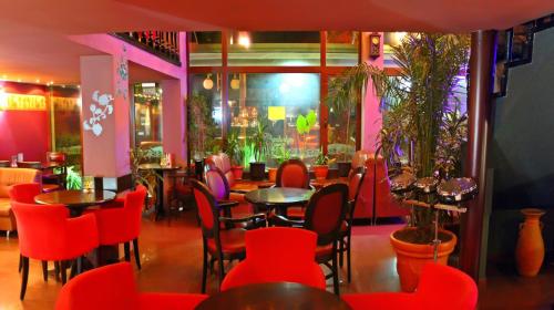 a restaurant with red chairs and tables in a room at Hotel Berito in Momchilgrad