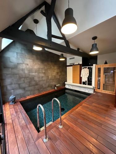 an indoor pool with a wooden floor and a swimming poolinteger at À contre courant in Forges-les-Eaux