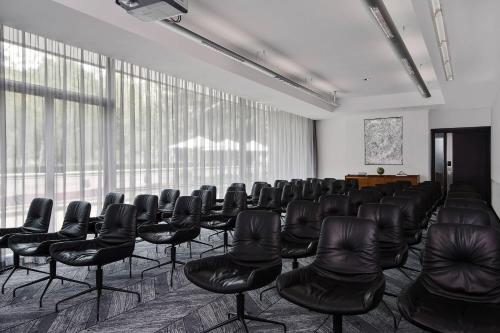 a conference room with black chairs and windows at Le Méridien Vienna in Vienna