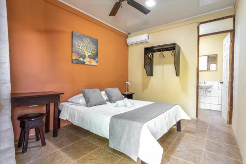 1 dormitorio con cama, escritorio y lavamanos en El Cocobolo Food&Rest Room 2 Bed and Breakfast WiFi AC Pkg gratis, 