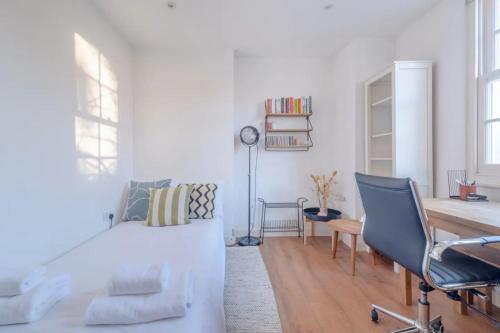 a white living room with a couch and a chair at Modern and Beautiful 2 Bedroom Flat - Haggerston in London