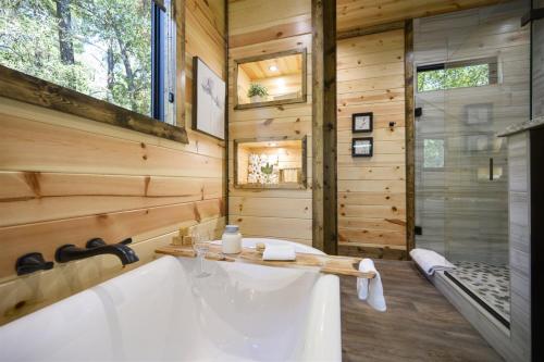 ein Badezimmer mit einer großen Badewanne in einem Holzhaus in der Unterkunft Skippin` Rocks in Broken Bow