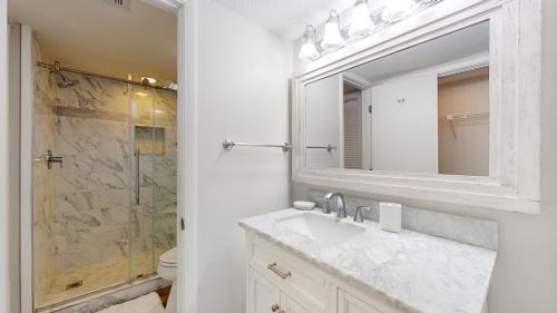 La salle de bains est pourvue d'un lavabo et d'une douche avec un miroir. dans l'établissement 1766 Saint Andrews Commons, à Île de Hilton-Head
