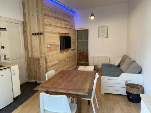 a living room with a table and a bed at Appartement 2 pièces Classé 2 * * in Janzé