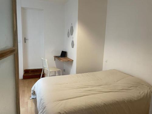 a bedroom with a bed and a desk and a chair at Appartement 2 pièces Classé 2 * * in Janzé
