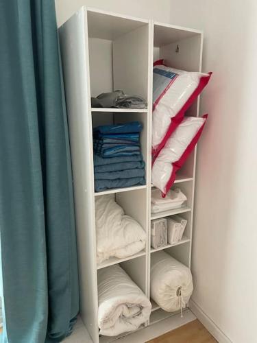 - un placard blanc avec des oreillers et un rideau bleu dans l'établissement Appartement 2 pièces Classé 2 * *, à Janzé