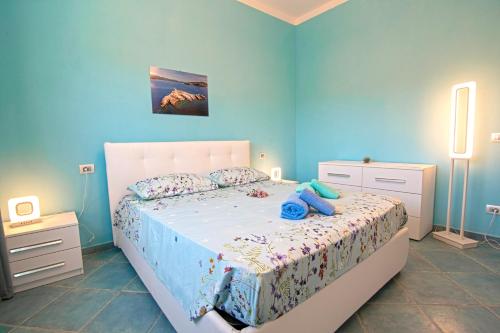 ein Schlafzimmer mit einem weißen Bett mit blauen Wänden in der Unterkunft Appartamenti Mare Portoferraio in Portoferraio