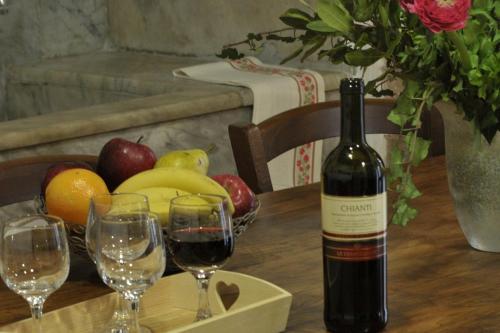 a bottle of wine sitting on a table with glasses at Antica Dimora in Monteroni dʼArbia