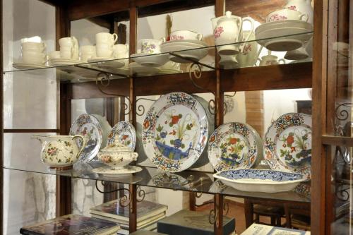 a shelf filled with plates and cups and bowls at Antica Dimora in Monteroni dʼArbia