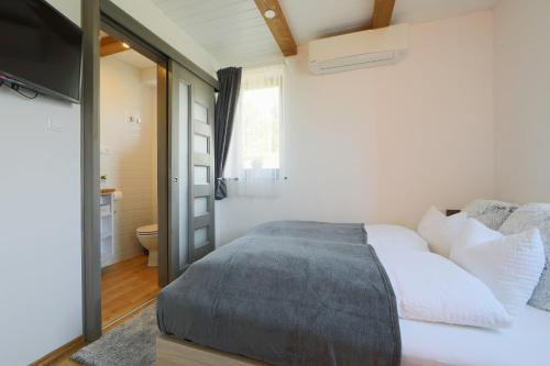 a bedroom with a bed and a television and a bathroom at Lotti Residence Harmony in Balatonfüred