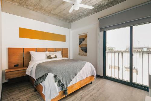 a bedroom with a bed and a large window at Vivotel Boutique in Guatemala