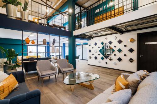 a lobby with couches and chairs and a table at Vivotel Boutique in Guatemala