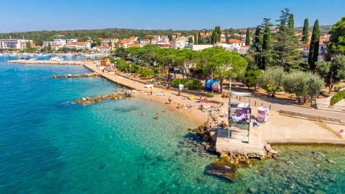 widok z lotu ptaka na plażę z ludźmi w wodzie w obiekcie Apartmani Totić w mieście Malinska