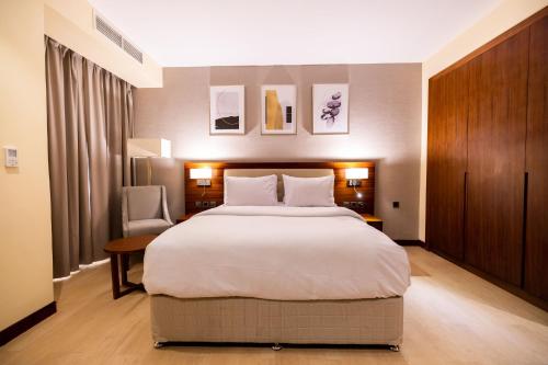 a hotel room with a large bed and a chair at Imperial Plaza Hotel, Juba in Juba