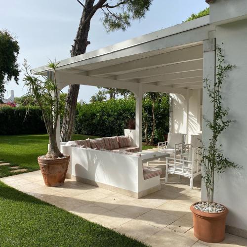 a white pergola with a couch under it at Gli Ulivi Rosamarina Ostuni in Rosa Marina