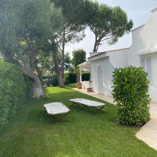 a yard with two picnic tables and a tree at Gli Ulivi Rosamarina Ostuni in Rosa Marina
