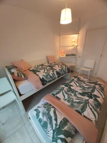 2 Betten in einem kleinen Zimmer mit einem Zimmer mit Aeromottermottermott in der Unterkunft Sea & the City in Blankenberge