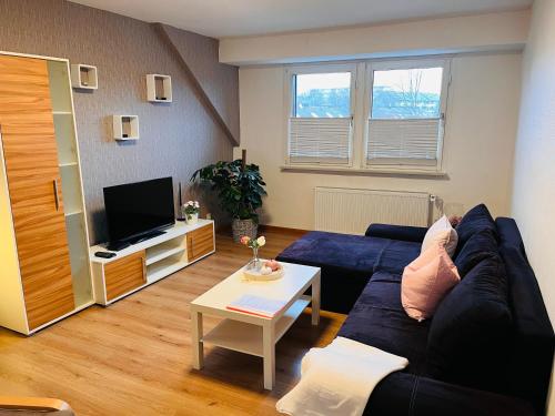 a living room with a blue couch and a tv at Ferienwohnung Götel in Gladbeck