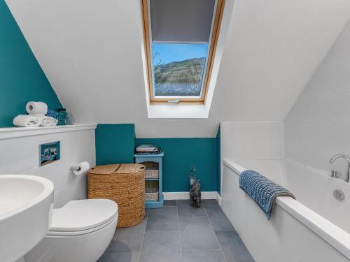 Un baño con inodoro, lavabo y bañera. en Cheerful Stays: 4 Bedroom Cottage in Arrochar, en Arrochar