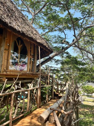 a house with a straw roof and a window at Antonio Beach Tree House Hotel & Spa in Uroa