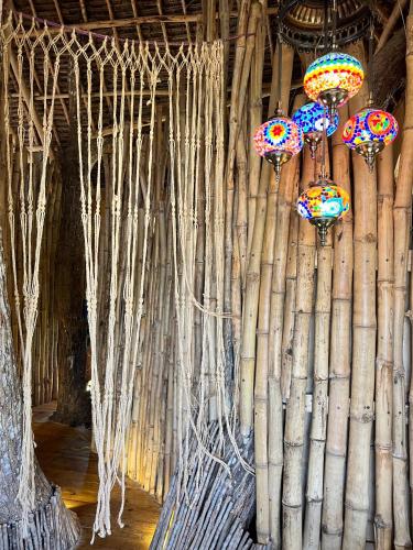 a room with a wall made of bamboo and lights at Antonio Beach Tree House Hotel & Spa in Uroa