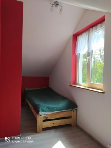 a small room with a green bed and a window at Całoroczny domek letniskowy nad zalewem Chańcza in Życiny