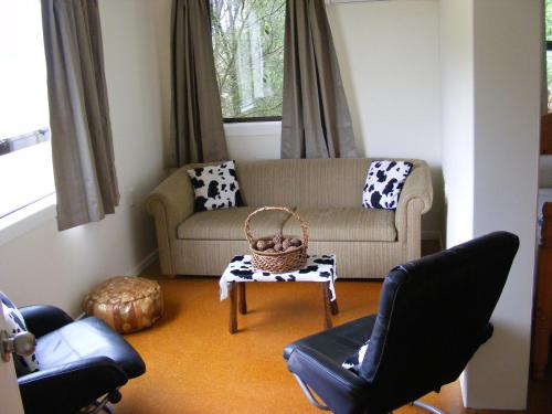 a living room with a couch and a table and chairs at Posto Bello in North Loburn