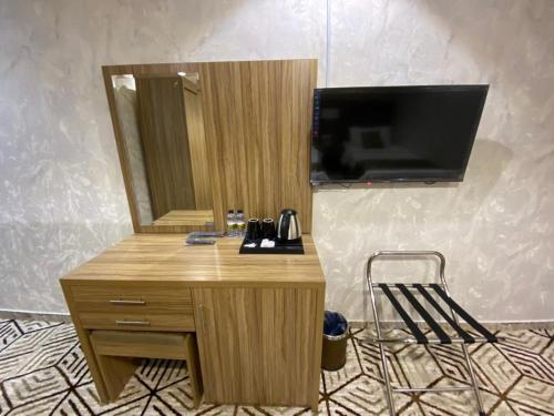 einen Schreibtisch mit einem Spiegel und einen TV an der Wand in der Unterkunft Seven Mountains Hotel فندق الجبال السبعة in Al Bad‘