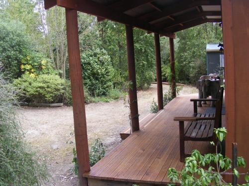 a wooden porch with a bench sitting on it at Posto Bello in North Loburn
