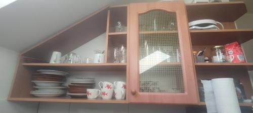a cabinet with plates and cups and dishes in it at Domek nad wodospadem in Zakopane