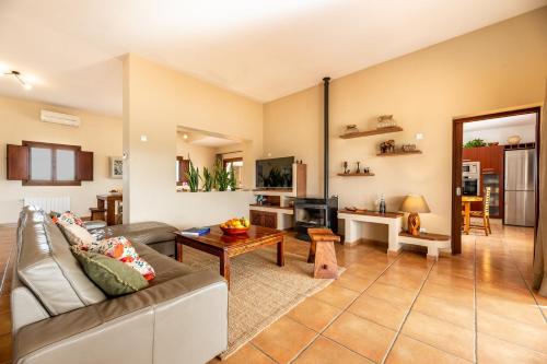 a living room with a couch and a table at Villa Can Jaume Arabí de Baix in Puig D’en Valls