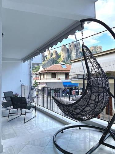- un hamac sur un balcon avec vue sur un bâtiment dans l'établissement M&F Meteora Apartments #1, à Kalambaka