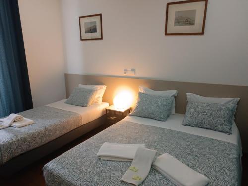 two beds sitting next to each other in a room at Pensao Nova Goa in Lisbon