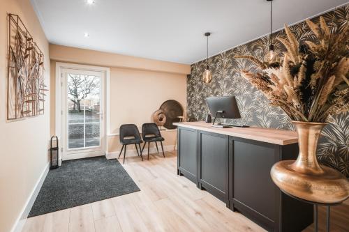 a home office with a desk and a vase with flowers at Hof van Halle in Halle