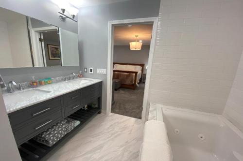 a bathroom with a tub and a sink and a mirror at Turret House at Birchwood in Harbor Springs