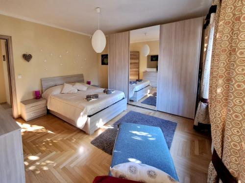 Habitación amplia con cama y espejo. en Maison Lydie, en Saint Vincent