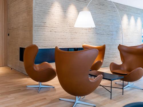 a row of chairs and a table in a room at Das Flint in Dornbirn