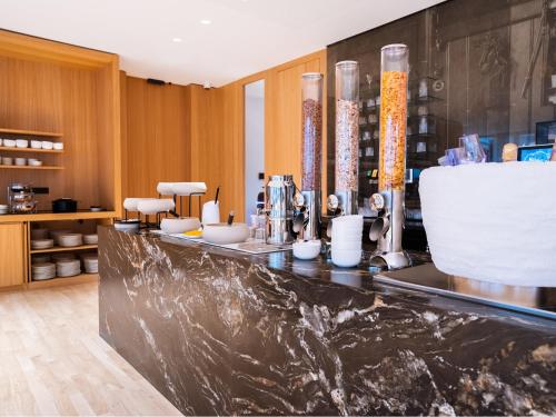 a bar in a kitchen with a counter top with vases at Das Flint in Dornbirn