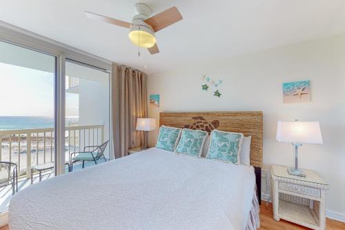 a bedroom with a bed with a view of the ocean at Pelican Beach Resort 818 in Destin