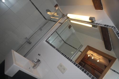 uma vista superior de uma casa de banho com um lavatório e um espelho em Gite ferme XVIII 4 chambres /8 personnes Chimay em Momignies
