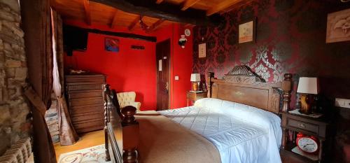 a bedroom with red walls and a bed in it at El Perlindango in Villademar