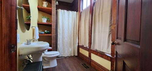 La salle de bains est pourvue d'un lavabo blanc et de toilettes. dans l'établissement The Carson House Bed & Breakfast, à Pittsburg