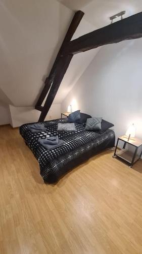 - un lit noir dans une chambre dotée de parquet dans l'établissement Duplex de Prestige, à Troyes