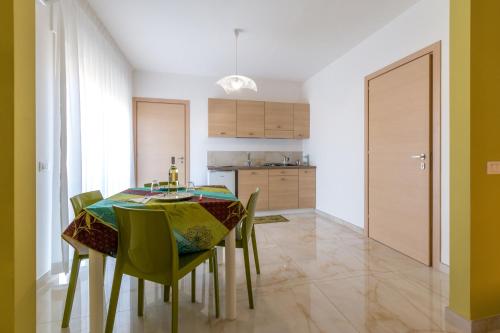 une salle à manger avec une table et des chaises vertes dans l'établissement Mare Manu Appartamento, à Porto Cesareo