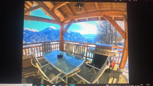 a view from the balcony of a cabin with a table and chairs at Chalet Mariabel in Puy-Saint-Pierre