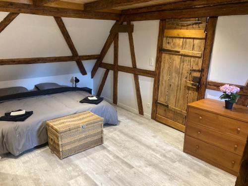 a bedroom with a bed and a dresser and wooden beams at Gite les Remparts de Turckheim in Turckheim