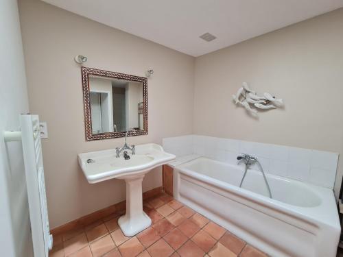 a white bathroom with a sink and a bath tub at Le Clos de Canet in Canet d'Aude